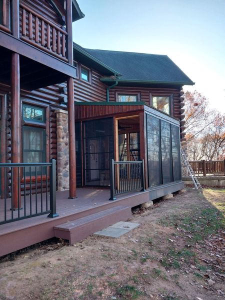 Wider view of the four-season room addition and deck on a log home