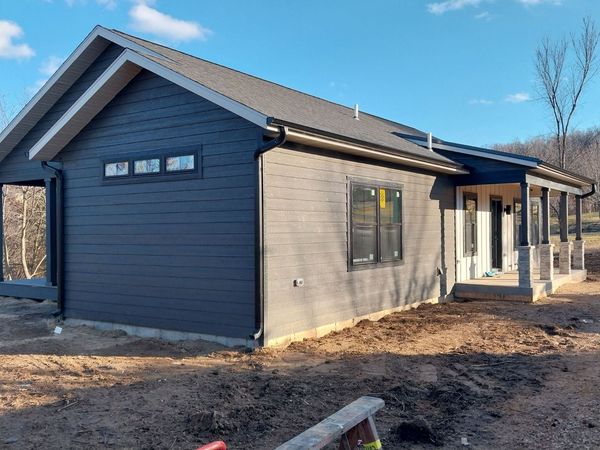 Side of a finished home in dark lap siding with clerestory windows