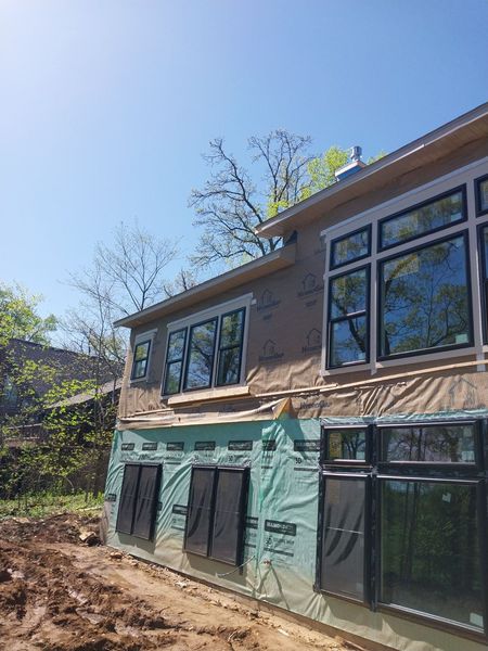 Large black-framed windows installed on a two-story addition