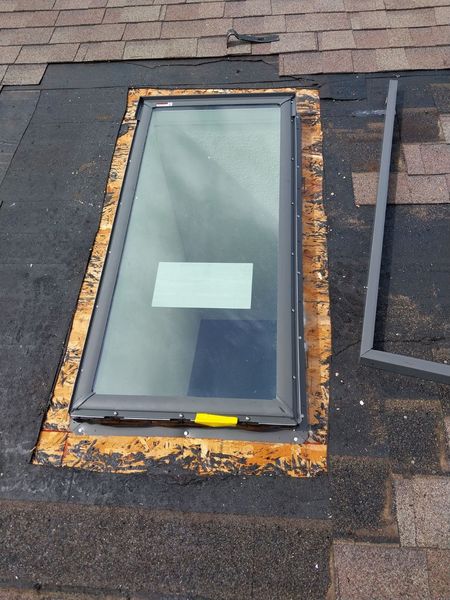 Roof skylight set in place with flashing membrane before shingling