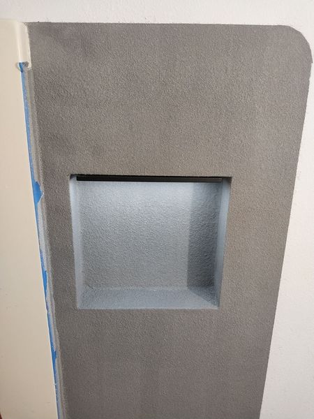 Microcement wall panel with a recessed shelf and a rounded top corner